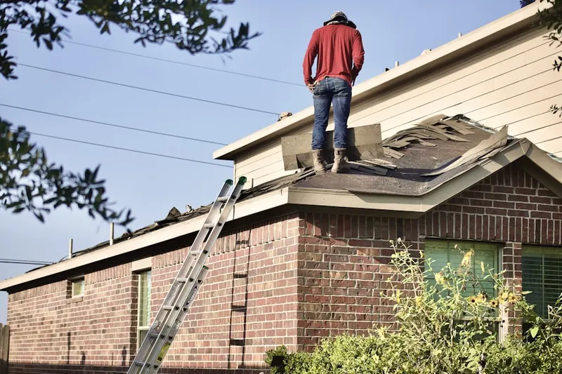 Professional roofer working on a residential roof in Ivory